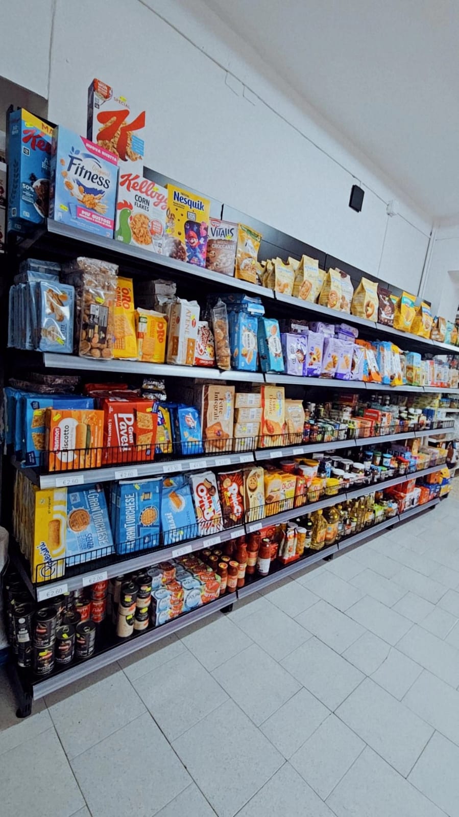 Scaffale con cereali, biscotti, fette biscottate, sughi e olio